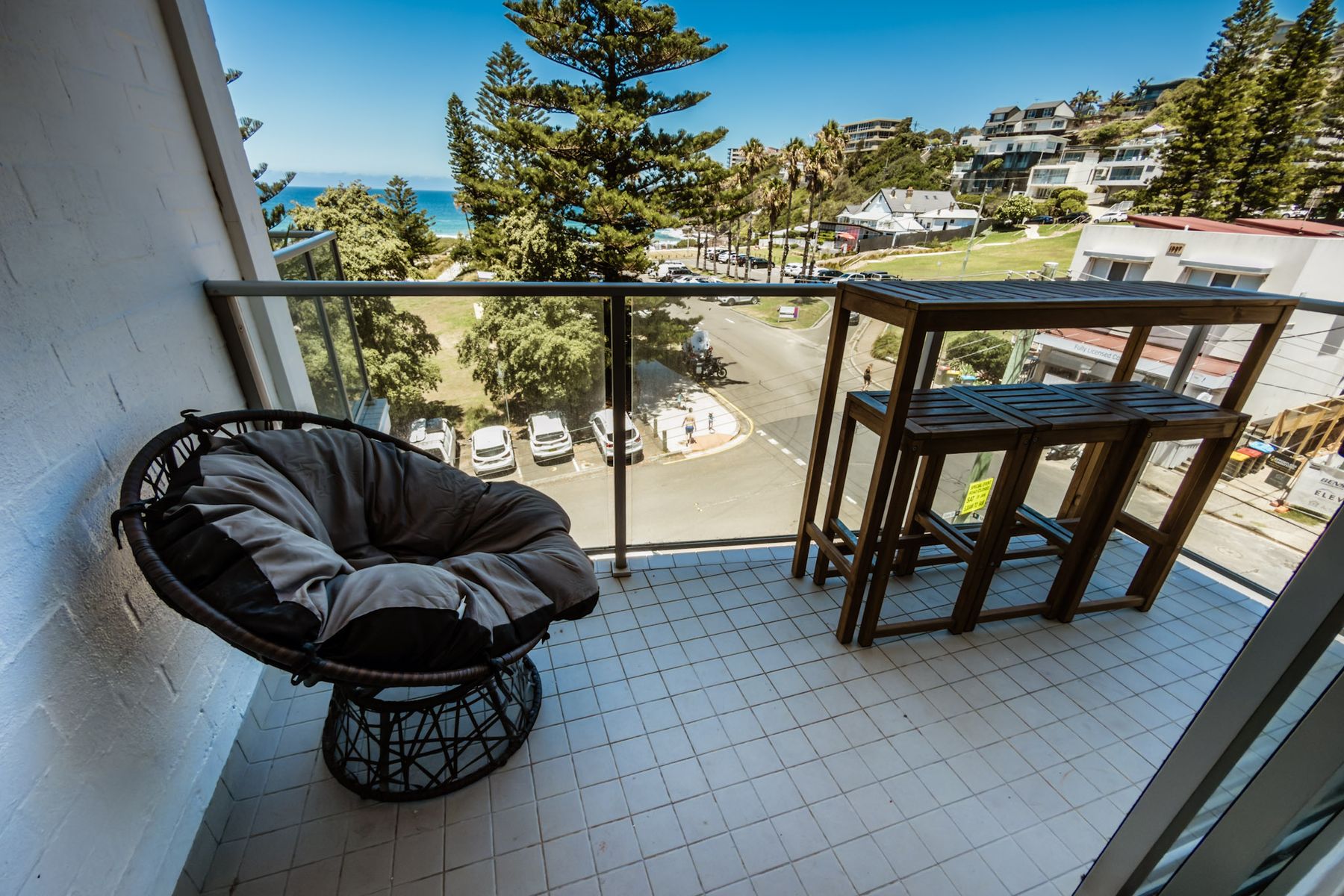Balcony above Freshwater Beach with the ocean visible past Norfolk Island pines
